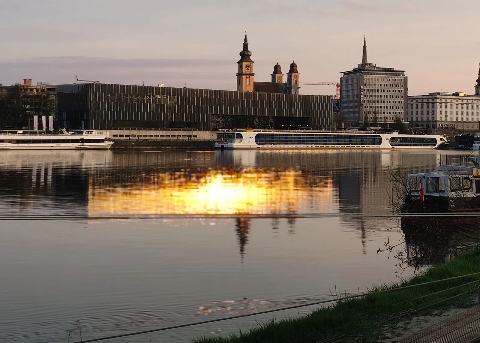 Stadtansicht von Linz mit Donau und historischen Gebäuden im Abendlicht